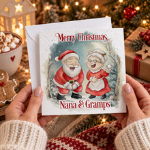 Load image into Gallery viewer, Personalised Christmas card for grandparents with Nana and Gramps text, held in hands in a cosy Christmas setting
